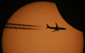 A picture taken through a telescope shows a silhouette of an aircraft against the sun during a partial solar eclipse in the settlement of Kojori outside Tbilisi, Georgia October 25, 2022. REUTERS/Irakli Gedenidze/File Photo 